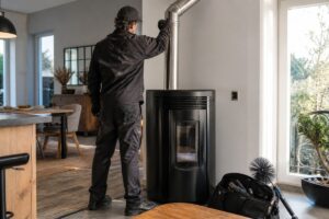 Technicien contrôlant le conduit d’un poêle à granulés